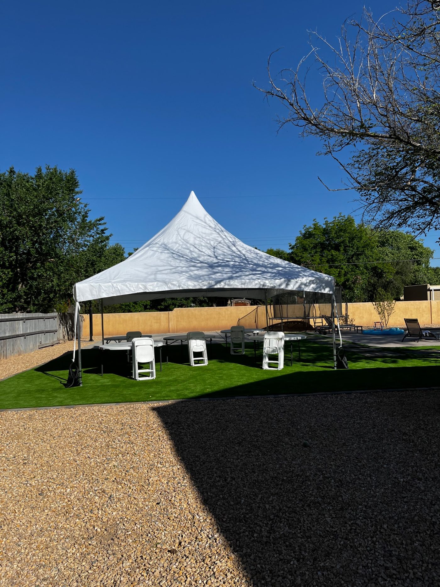 20x20 high peak tent setup with tables and chairs on turf