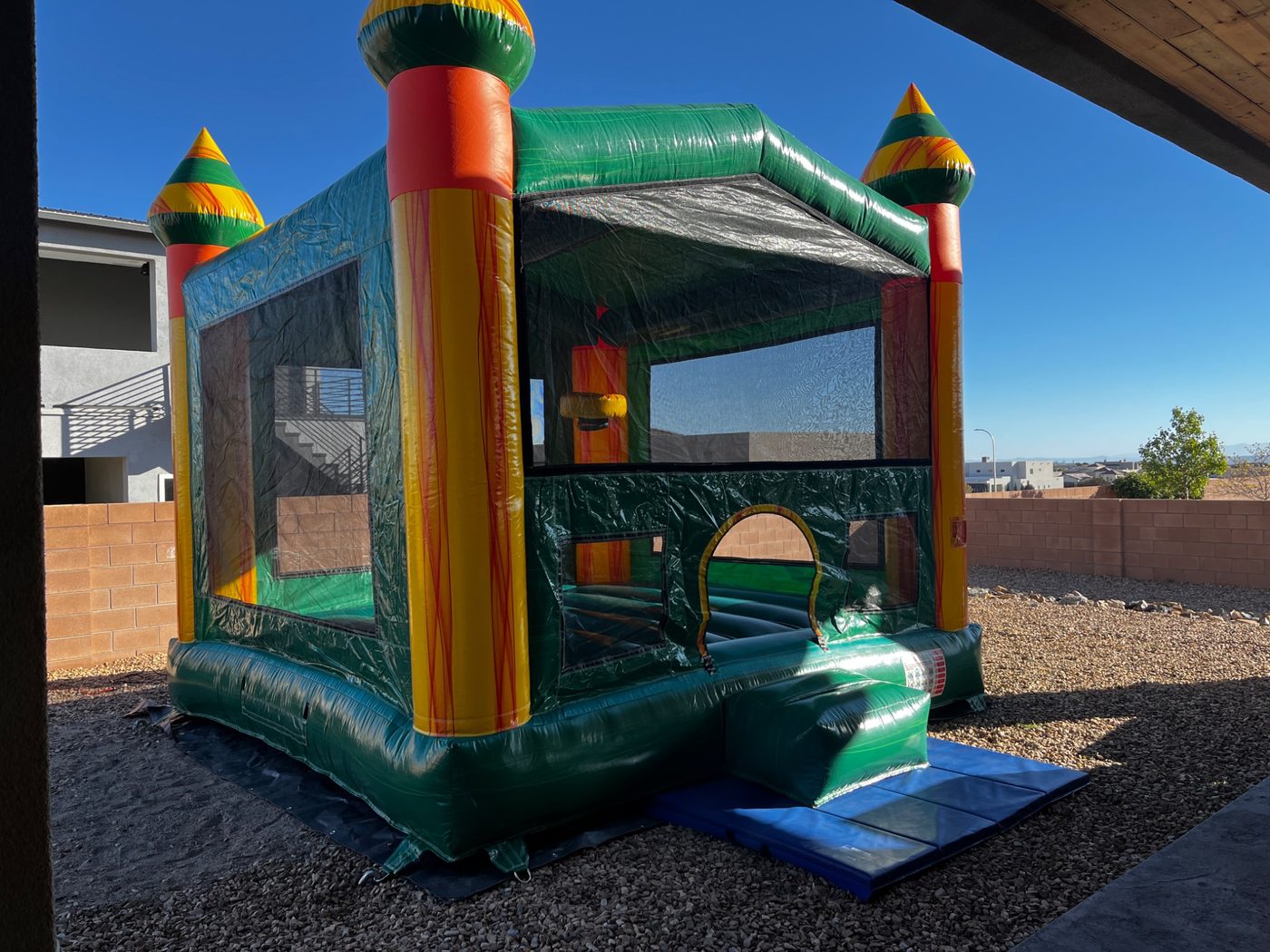 Colorful castle bounce house setup with safety mats